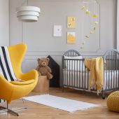 yellow-armchair-teddy-bear-and-crib-in-a-modern-ki-F5JHBNQ-scaled.jpg